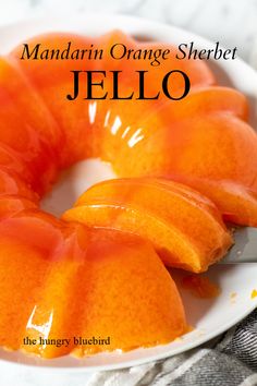 the mandarin orange sherbet jello is on a white plate with a knife