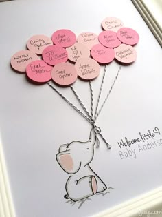 a card with pink and white hearts attached to the back of an elephant holding balloons