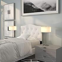 a white bed sitting in a bedroom next to two lamps