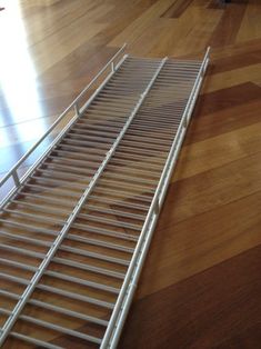 a metal shelf sitting on top of a hard wood floor