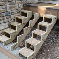 some steps made out of wood sitting in front of a stone wall and brick building