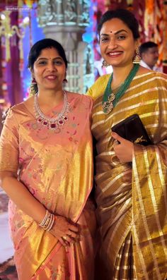 two women standing next to each other in sari