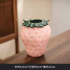 a pink vase sitting on top of a wooden table