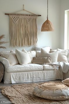 a living room filled with lots of white furniture and pillows on top of a rug