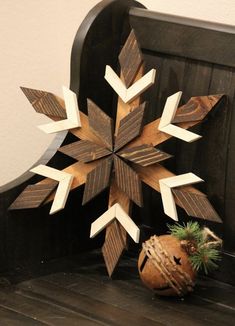 a wooden snowflake sitting on top of a bench next to a potted plant