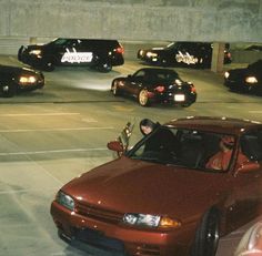 a group of cars driving down a street next to each other in parking garages