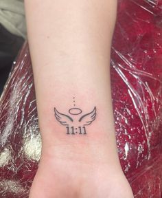 a small tattoo on the foot of a woman's left foot, with an angel wing