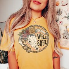 "The \"Wild Soul\" T-shirt captures the untamed spirit within you. With a design that embraces freedom and individuality, this shirt is perfect for those who dare to be different. The front showcases the words \"Wild Soul\" in bold, dynamic typography, representing the adventurous and uninhibited nature of your inner self. Comfort Colors introduces its garment-dyed t-shirt; a fully customizable tee made 100% with ring-spun cotton. The soft-washed, garment-dyed fabric brings extra coziness to your wardrobe while the relaxed fit makes it an excellent daily choice. The double-needle stitching throughout the tee makes it highly durable while the lack of side-seams helps the shirt retain its tubular shape. .: 100% ring-spun cotton .: Medium fabric (6.1 oz/yd² (206.8 g/m .: Relaxed fit .: Sewn-i Free-spirited Cotton T-shirt With Graphic Print, Free-spirited Cotton Crew Neck T-shirt, Free-spirited Short Sleeve Graphic T-shirt, Free-spirited Short Sleeve T-shirt With Graphic Print, Free-spirited Graphic Print Short Sleeve T-shirt, Self Comfort, Dynamic Typography, Western Tee, Distressed T Shirt