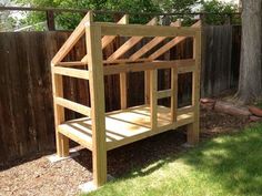 a wooden bunk bed sitting on top of a dirt field