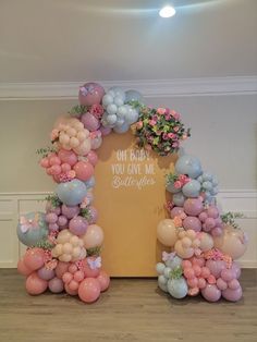 an arch made out of balloons and flowers