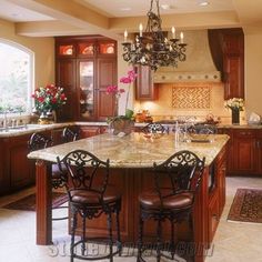 a large kitchen with marble counter tops and wooden cabinets