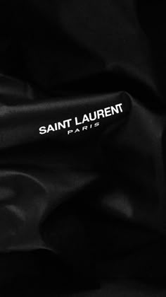 the saint laurent brand logo is shown on a black satin fabric