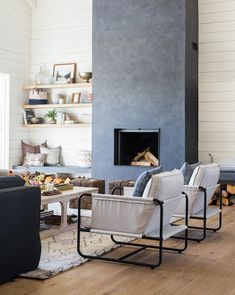 a living room filled with furniture and a fire place next to a wall mounted fireplace