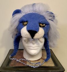 a crocheted blue and white lion head on a mannequin's head