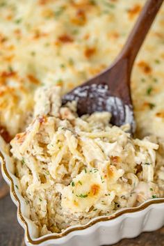 a casserole dish filled with chicken salad and a wooden spoon on the side