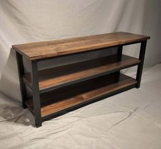 a wooden shelf sitting on top of a white sheet covered floor next to a wall