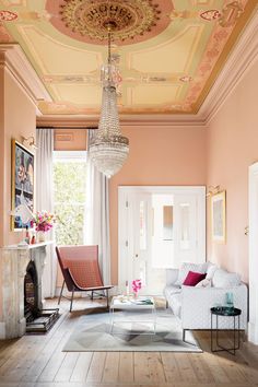 a living room filled with furniture and a chandelier hanging over the top of it