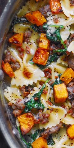 pasta with sausage, spinach and cheese in a pan