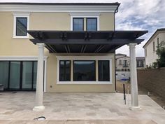 an outdoor covered patio in front of a house