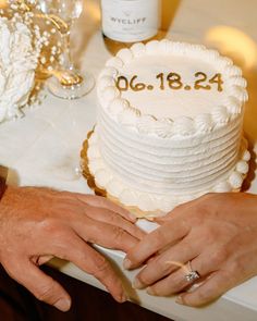 two people holding hands over a wedding cake