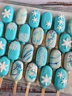 there are many blue and white treats on the stick with snowflake designs in them