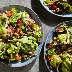 three plates filled with salad on top of a table