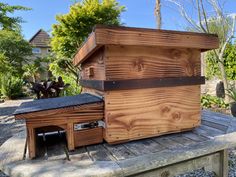 a wooden bird house sitting on top of a wooden bench