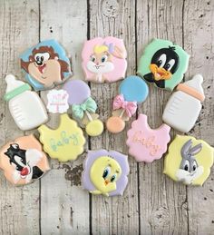 some decorated cookies are sitting on a wooden table with the words baby spelled in different languages