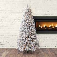 a white christmas tree sitting in front of a fireplace