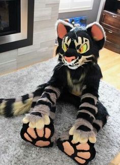 a black and white cat laying on top of a carpet next to a fire place