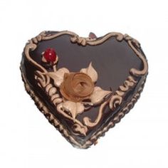 a heart shaped chocolate cake with a rose on the top and an embellishment in the middle