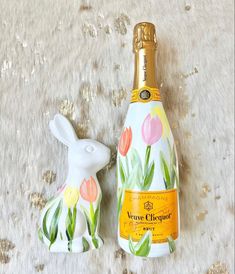 a white rabbit figurine next to a bottle of champagne