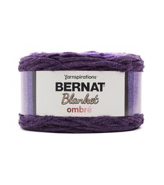 yarn ball in purple and white with the label bernat blanket ombre on it