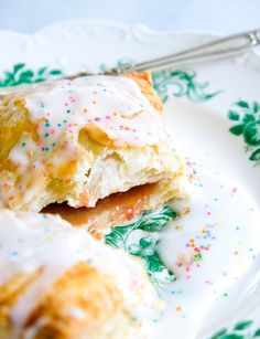 a white plate topped with pastry covered in frosting and sprinkles