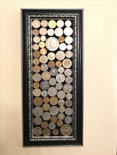 a framed coin display in the corner of a room with a wall hanging on it