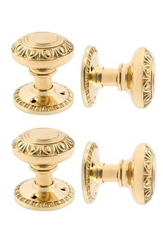 three gold door knobs with decorative designs on the front and back of each one