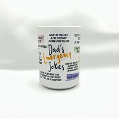 a coffee mug with the words dad's emergency jokes written on it, in front of a white background