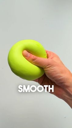 a hand holding a green doughnut with the word smooth on it's side