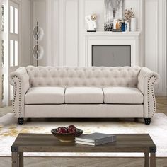 a living room with a couch, coffee table and books on the floor in front of a fireplace