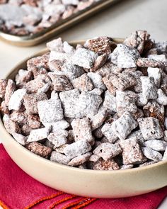 a bowl full of muddy dog treats sitting on top of a red place mat next to a metal tray