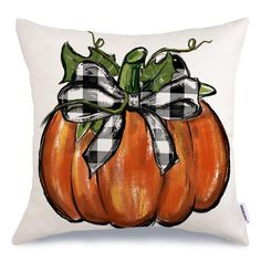 an orange pumpkin with a bow on it's back is sitting on a white pillow