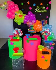 an assortment of colorful balloons and decorations on display in front of a black backdrop with stars