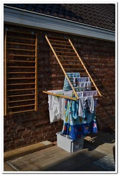 clothes hanging out to dry in the sun on a clothes line outside a brick building