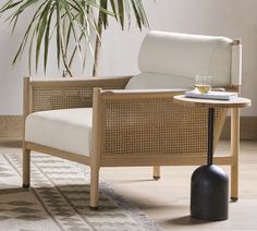 a living room with a chair, table and potted plant