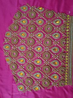 a pink cloth with gold and green designs on it's side, sitting on a table