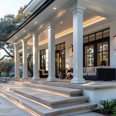 an outdoor living area with stairs leading up to the front door and covered in white columns