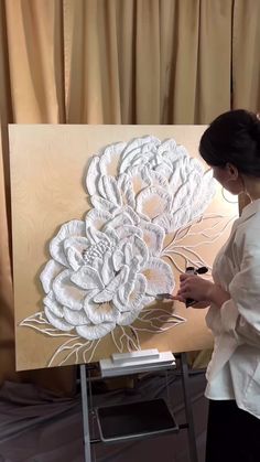 a woman is working on an art piece