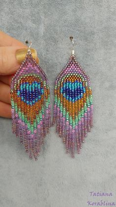 a pair of colorful beaded earrings in the shape of a peacock