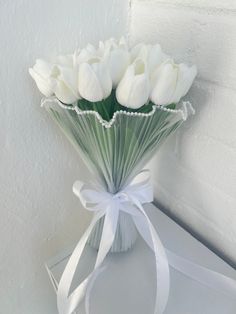 a bouquet of white tulips tied with a ribbon