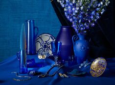 blue vases and other decorative items sit on a blue tablecloth with gold accents